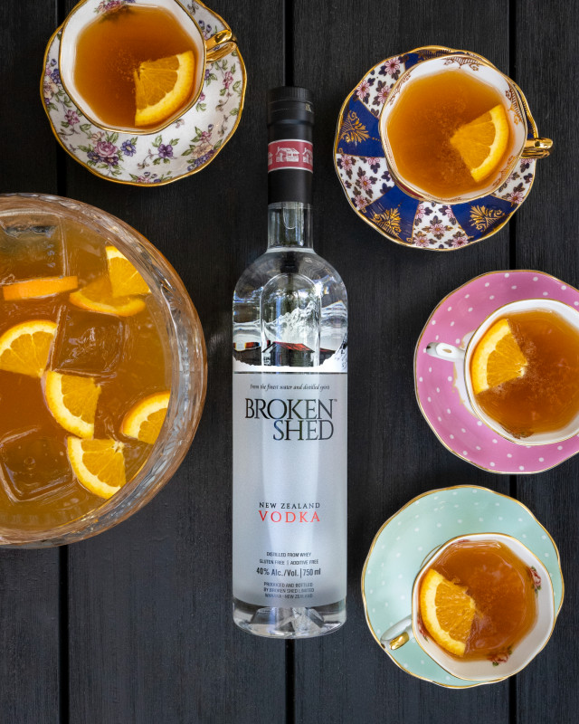 An orange bowl of punch with a bottle of Broken Shed