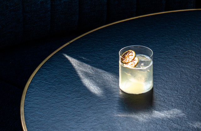 A cocktail sits on a black table